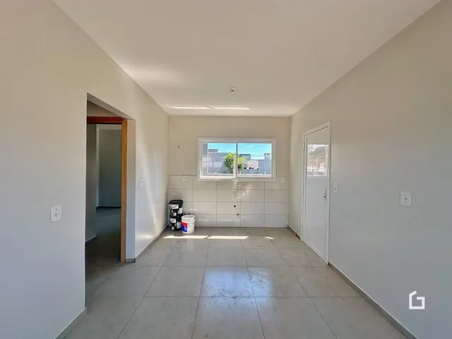 Hall de entrada com piso de cerâmica e janela mostrando a vista externa.