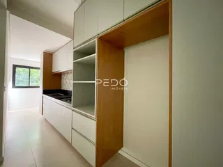 Um corredor interno de uma residência com acabamentos brancos.