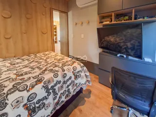 Quarto com cabeceira de madeira e decoração temática de motocicletas.