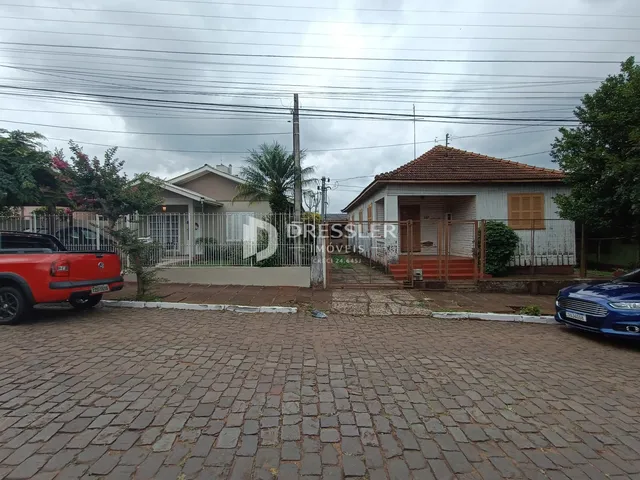 Fachada de uma residência em Lajeado, Brasil, com cerca e paisagismo na frente.