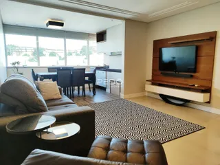 Sala de estar com vista para o exterior e mesa de jantar.