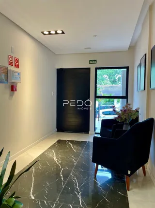 Sala de estar com piso de mármore escuro e porta escura.