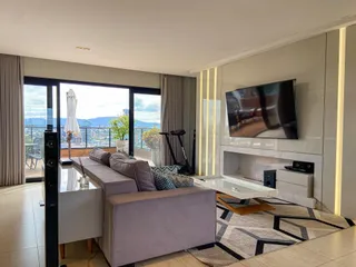 Sala de estar moderna com grande janela e vista panorâmica.