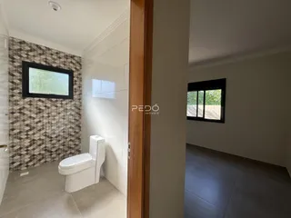Banheiro com revestimento de azulejos geométricos na parede.