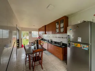 Imagem de uma cozinha com armários de madeira e piso de cerâmica.