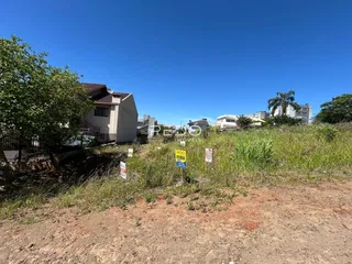 Vista externa de uma propriedade com terreno e vegetação ao ar livre.