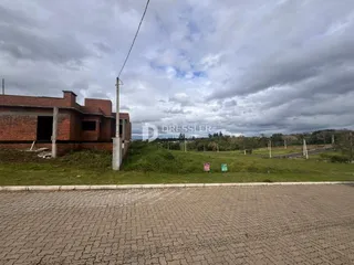 fachada de uma residência de tijolos em Lajeado, Brasil, com área gramada à frente.