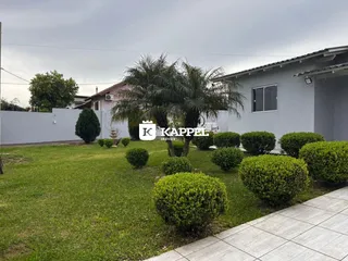 Fachada de uma residência em Lajeado, Brasil, com jardim frontal e paisagismo.