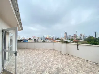 Varanda externa com piso de cerâmica e vista da cidade.