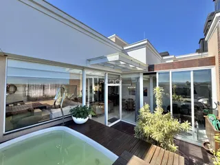 Fachada de uma residência moderna com área externa e piscina.