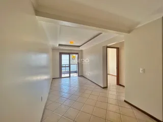 Corredor com piso de cerâmica que leva a uma porta de vidro.