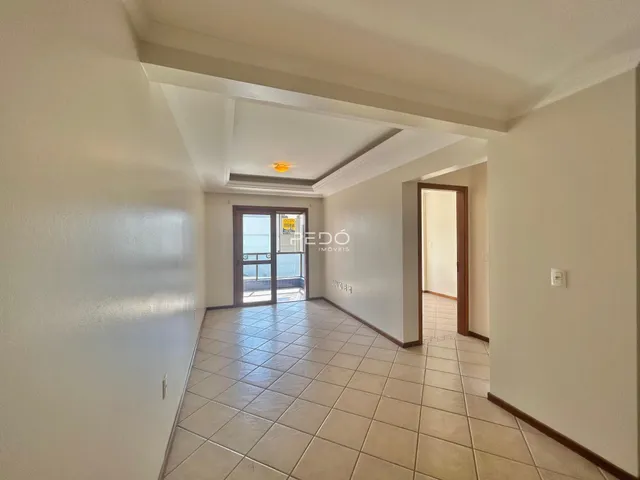 Corredor com piso de cerâmica que leva a uma porta de vidro.