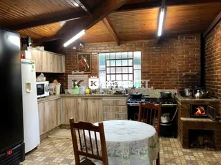 Mesa de jantar com detalhes em madeira e parede de tijolos expostos.