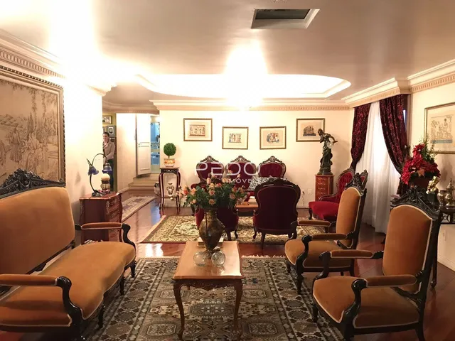 Sala de estar com decoração clássica e móveis de madeira escura.