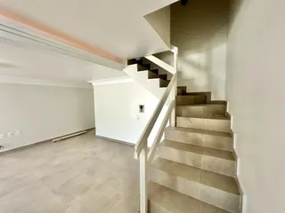 Hall de entrada com piso de cerâmica e escadaria em um imóvel no Brasil.