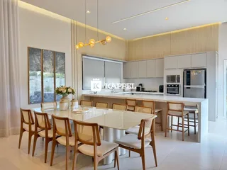 Cozinha moderna com ilha central e bancadas claras em um ambiente bem iluminado.