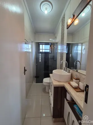 Foto de um banheiro com revestimento branco e bancada de mármore.