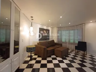 Sala de estar com piso xadrez preto e branco e sofá marrom.