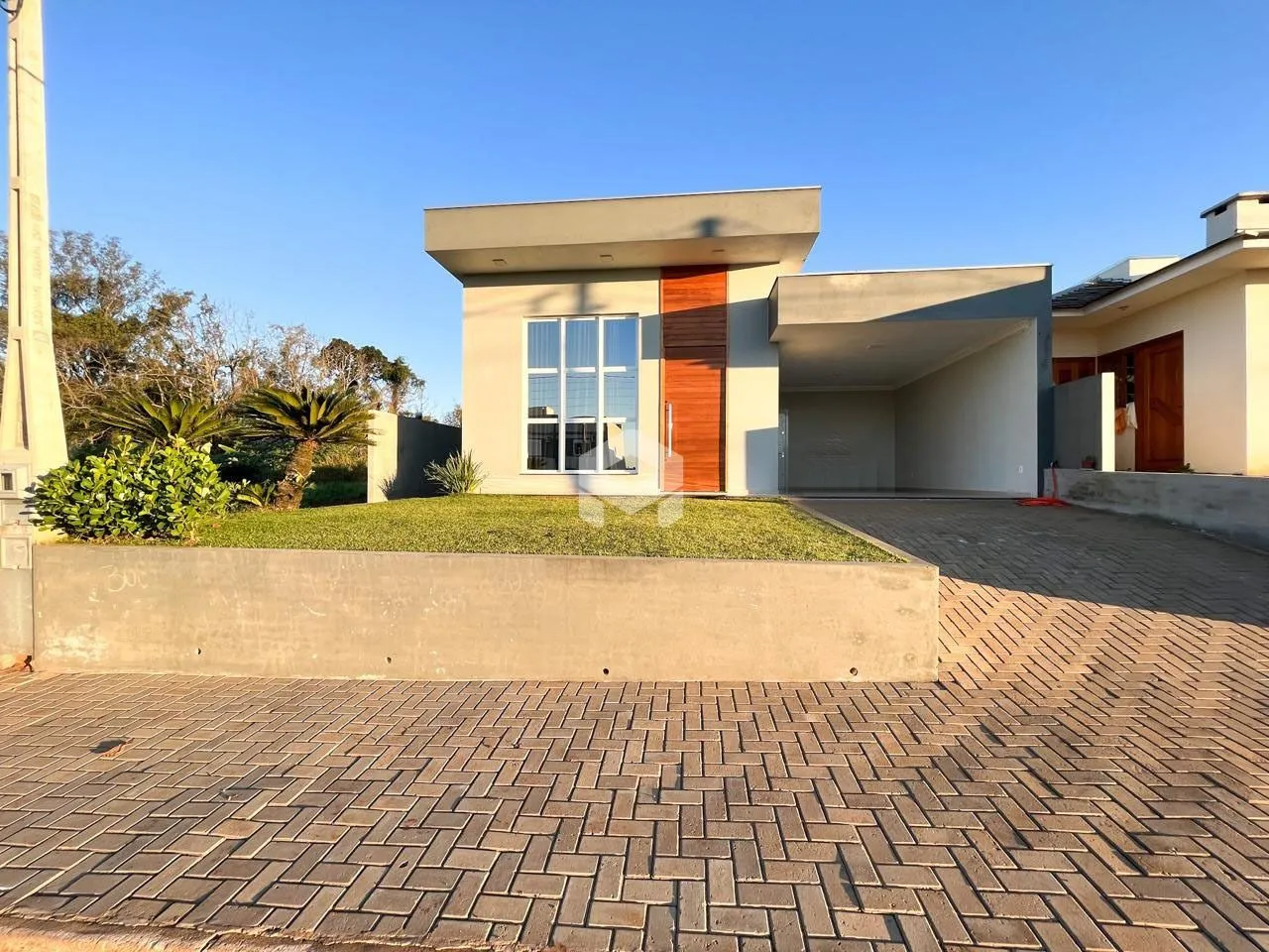 Fachada moderna de uma residência em Lajeado, Brasil, com área de garagem e paisagismo.