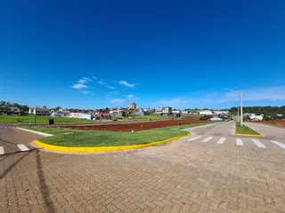 Vista externa de uma área aberta com gramado e céu azul claro.