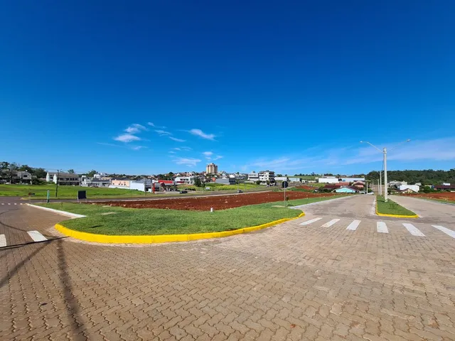 Vista externa de uma área aberta com gramado e céu azul claro.