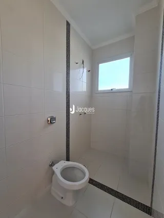 Foto de um banheiro interno com piso e azulejos brancos.