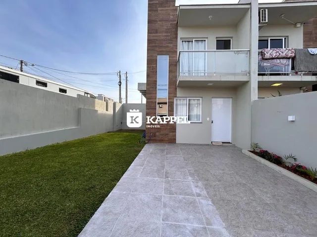 Vista externa de um prédio residencial em Lajeado, Brasil, mostrando a fachada e um jardim.