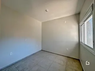 Ambiente interno com paredes brancas e piso de cerâmica em um imóvel.