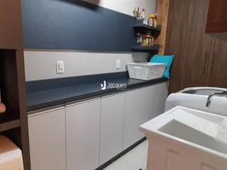 Vista de uma cozinha com armários e bancadas em tons de cinza e branco.