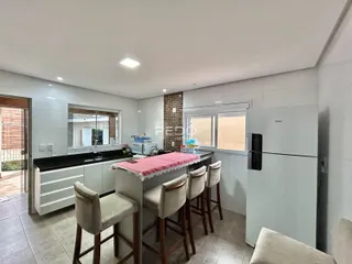 Foto de uma cozinha moderna com armários brancos e bancadas escuras.
