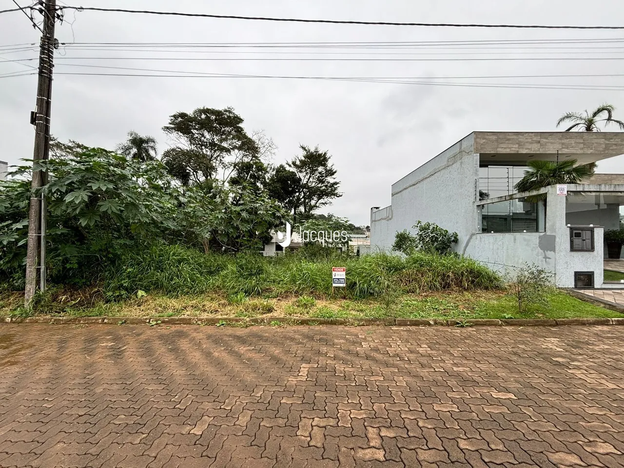 Fachada de uma residência em Lajeado, Brasil, com vegetação ao fundo.