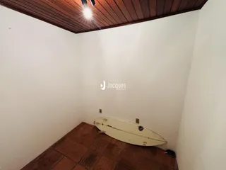 Vista interna de um cômodo com teto de madeira e piso de terracota.