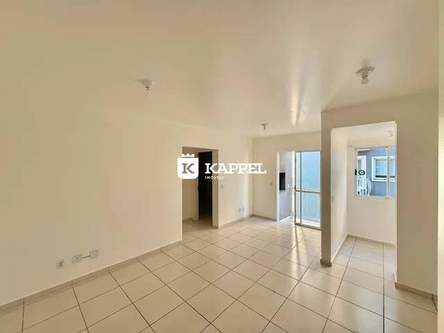 Vista interna de um ambiente amplo com piso de cerâmica e paredes brancas.