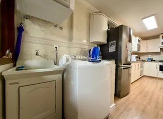 Uma cozinha com armários brancos e eletrodomésticos.