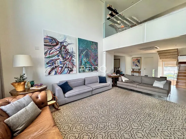 Sala de estar com sofá e obras de arte em um apartamento no Brasil.