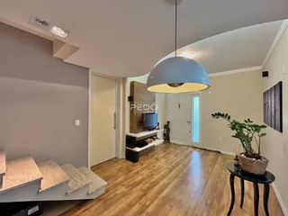 Sala de estar com piso de madeira e paredes cinzas.