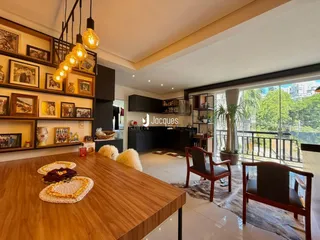 Ambiente interno de uma sala de estar com decoração rústica e grandes janelas.
