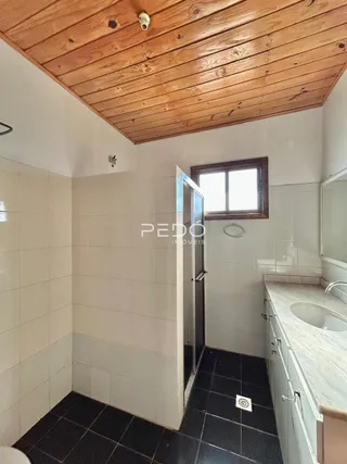 Interior de um ambiente com piso escuro e teto de madeira.