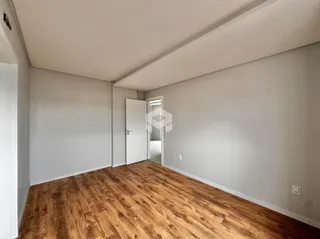Uma foto de um cômodo interno com piso de madeira.