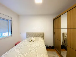 Quarto com cama e armário de madeira em um imóvel.