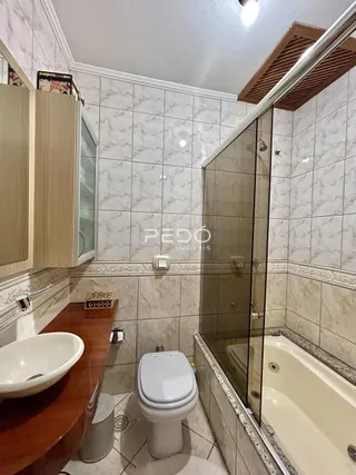 Foto de um banheiro com revestimento de azulejos brancos e bancada de madeira.
