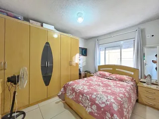 Quarto com armário de madeira e cama de casal.