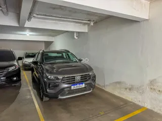 Foto de uma garagem com dois veículos estacionados em um pátio.