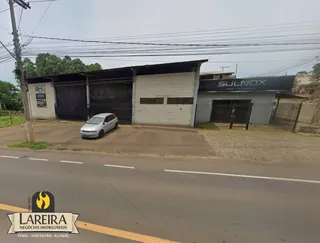 Fachada de um imóvel em Lajeado, Brasil, com cerca e veículo na frente.