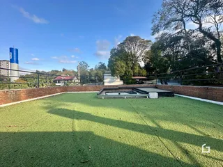 Gramado verde com muro de tijolos e grade de metal em uma propriedade.