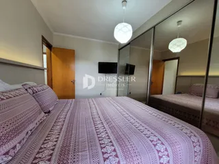 Quarto com duas camas e decoração em tons de rosa e branco.