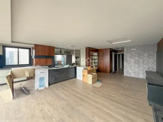 Interior de uma sala de estar em construção com piso de madeira.