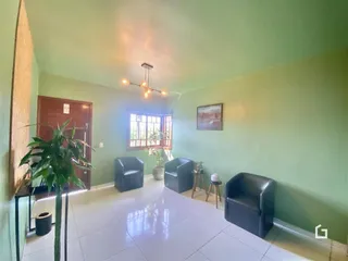Sala de estar com paredes verdes e piso branco em uma residência.