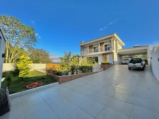 Fachada de uma casa moderna em Lajeado, Brasil, com área externa pavimentada.