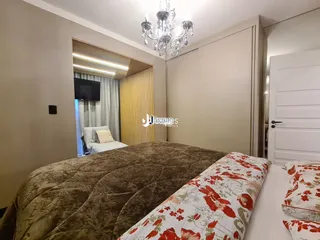 Quarto com cama grande e cortinas claras em um imóvel no Brasil.